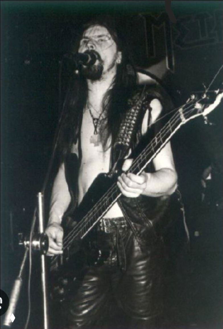 Чёрно-белая сценическая фотография музыканта с бас-гитарой во время выступления в клубе, атмосферный снимок живого концерта.