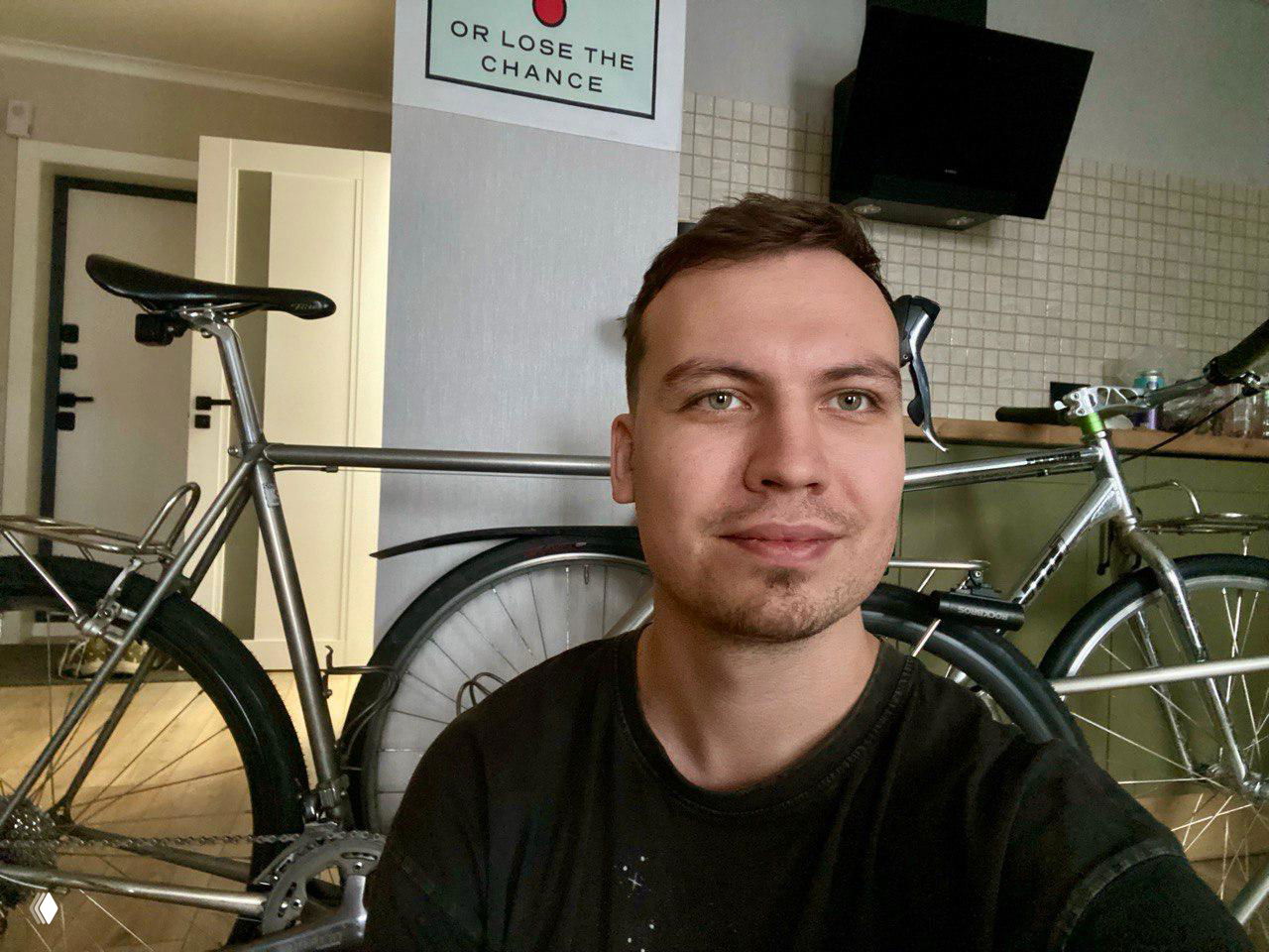 Селфи мужчины на фоне велосипеда в интерьере — демонстрация выкупа и доставки велосипедов и запчастей из Европы.