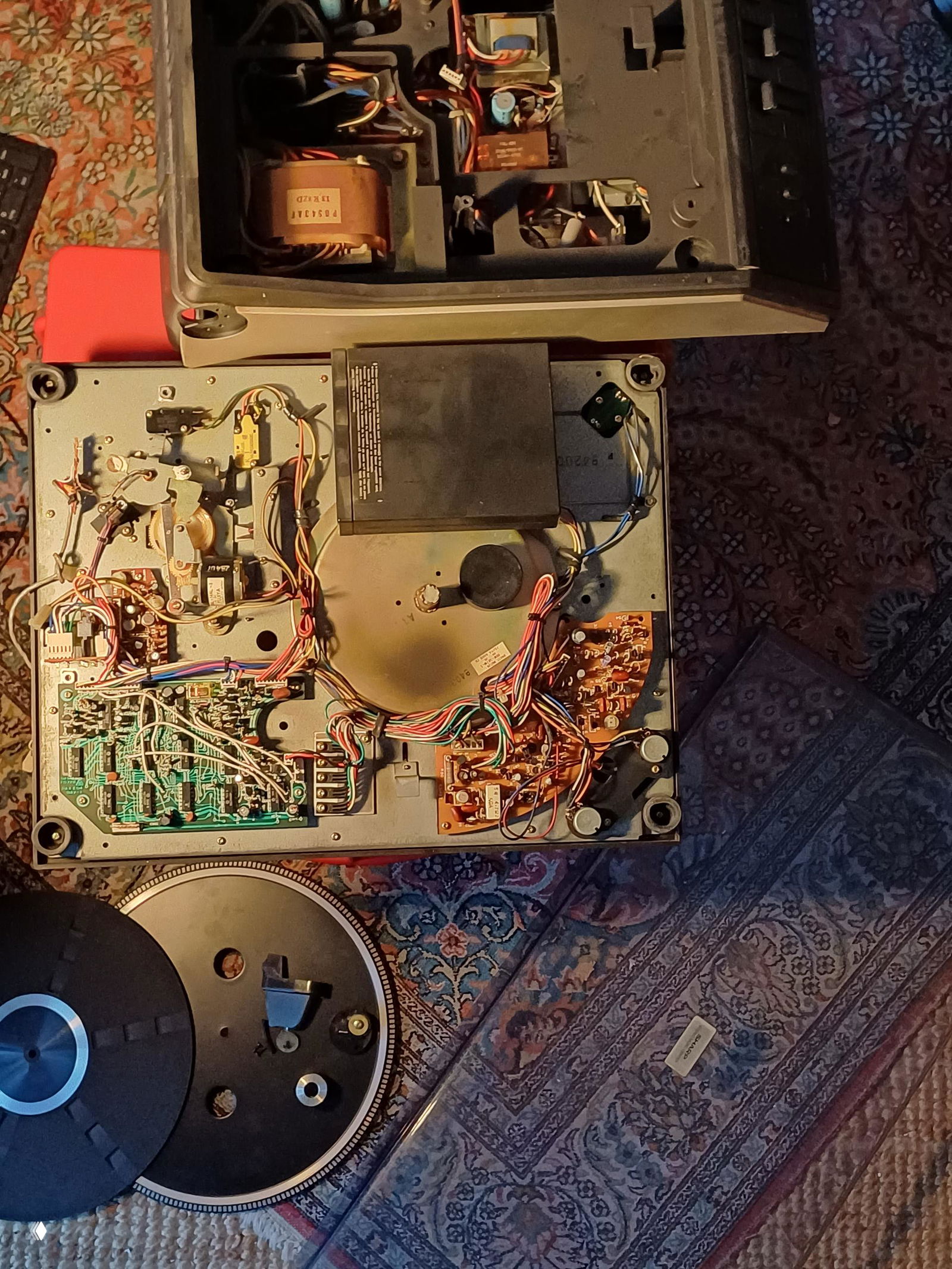 Внутренности разложенного медиа-центра: трансформатор, платы и проводка, видны детали механики вертка и электроники для оценки состояния перед отправкой.