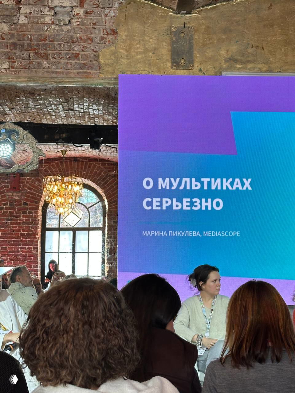 Зал с аудиторией и крупный экран с надписью «О мультиках серьёзно», спикеры обсуждают анимацию на тематическом блоке форума.