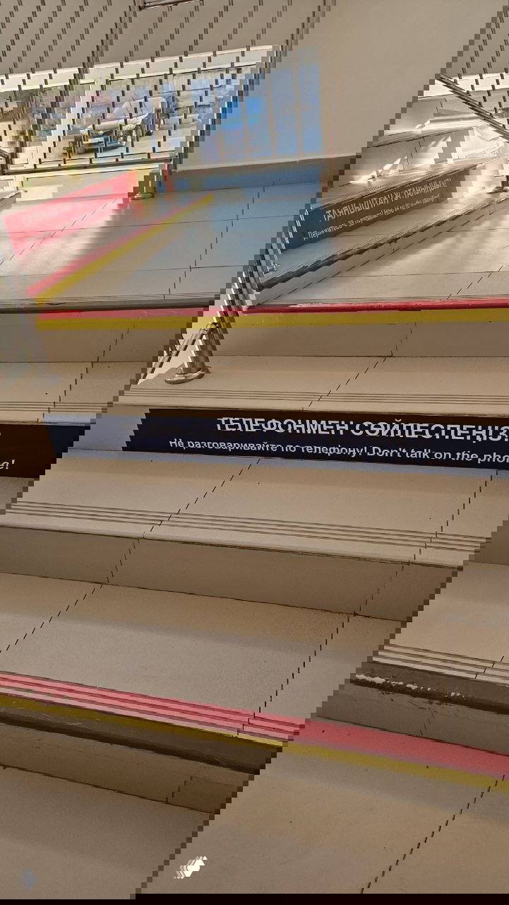 Ступеньки в государственной поликлинике Алматы с надписью на трёх языках «Не разговаривайте по телефону / Don't talk on the phone».