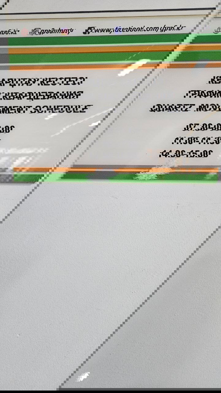 Информационная табличка в коридоре поликлиники Алматы: график кварцевания (Quartz movement schedule) с указанными временными интервалами.