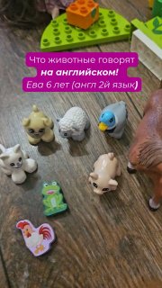 Превью видео с игрушечными фигурками животных и наклейками на деревянном столе; кадр для ролика о том, как животные звучат на английском языке.