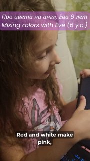 Девочка примерно шести лет смотрит в планшет; на экране видно подпись на русском и английском с примером смешения цветов: «Red and white make pink».