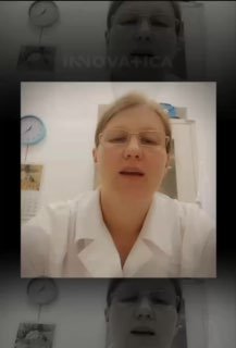 Врач в белом халате на превью видео клиники INNOVATICA, крупный план лица в кабинете с часами на стене; рассказ о горячей лихорадке у ребёнка и методах ухода.