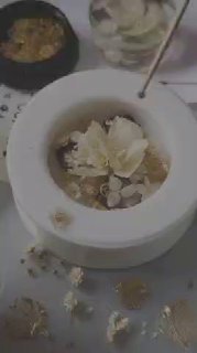 Крупный план процесса создания украшения: заливка смолы в круглый молд с сухоцветами и золотыми вставками на рабочем столе