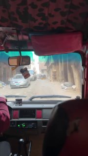 Салон тук-тука во время езды по заваленной улице: вид вперёд по дороге с пылью и обочинами, типичный транспорт по окраинам Каира.