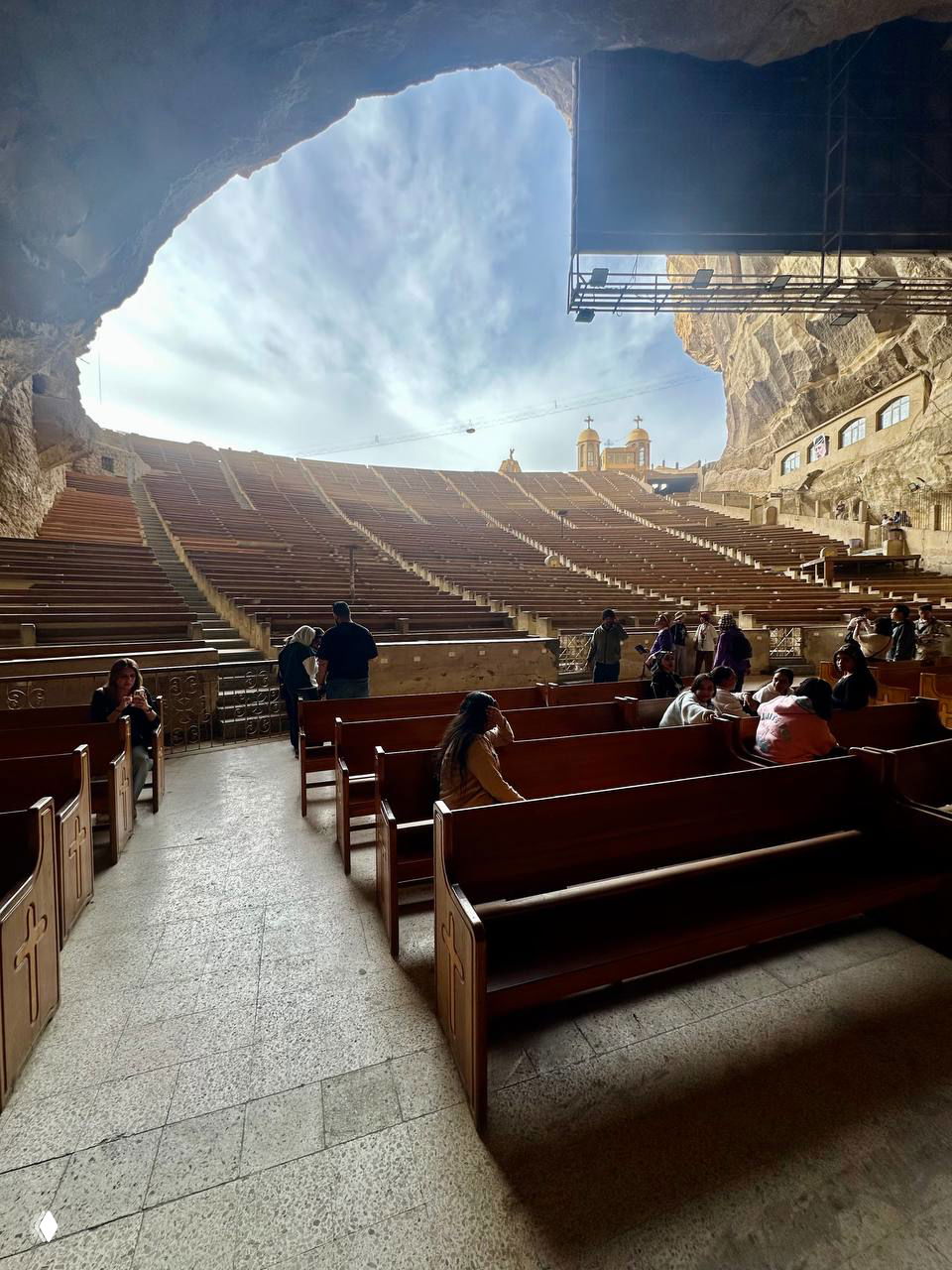 Подробный план скальной стены внутри храма: высеченные ниши, лестницы и рельефы над рядами сидений — впечатляющая масштабность росписи в камне.