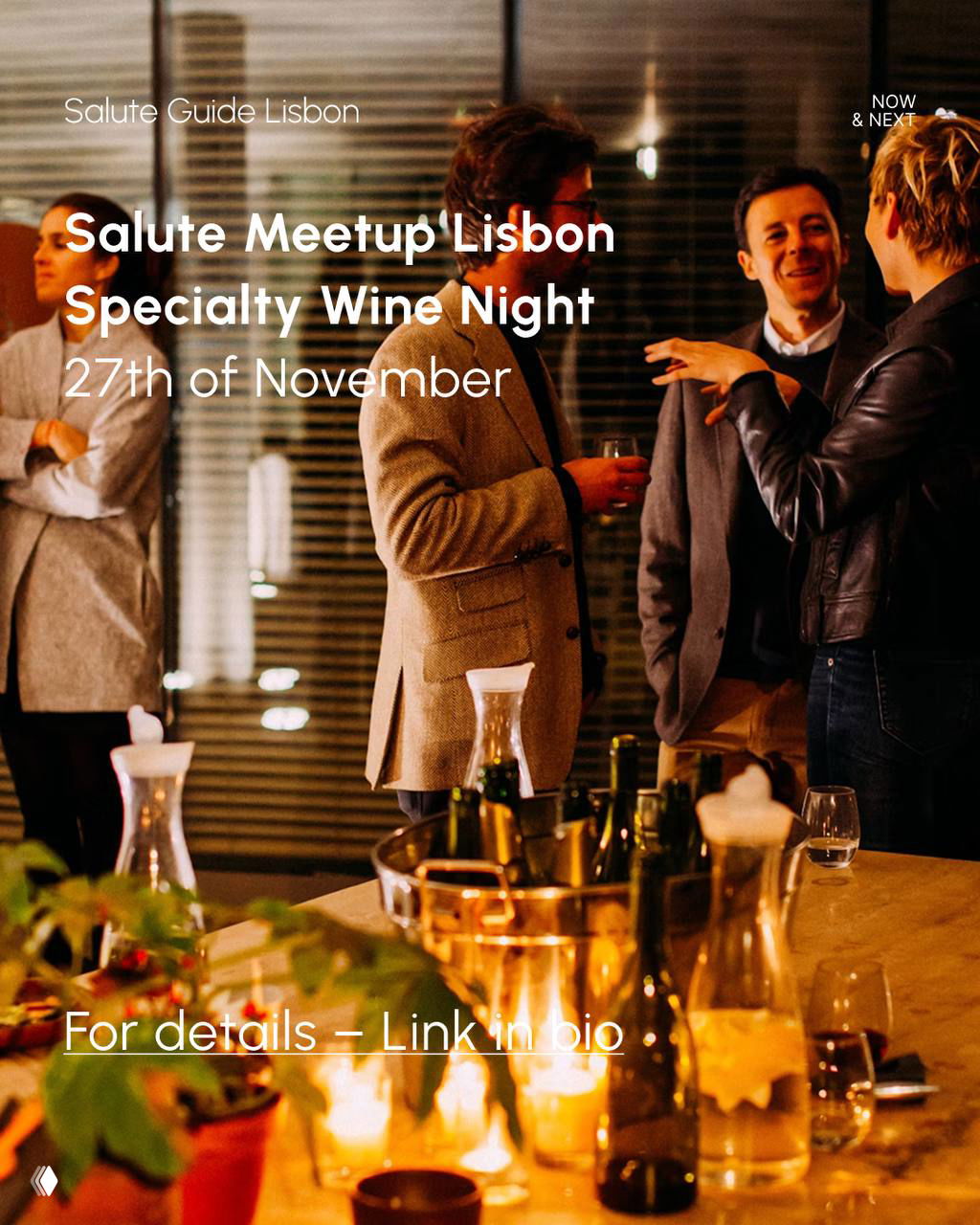 People chatting at an evening wine meetup in Lisbon, guests in conversation with glasses on a convivial table set with candles and bottles.