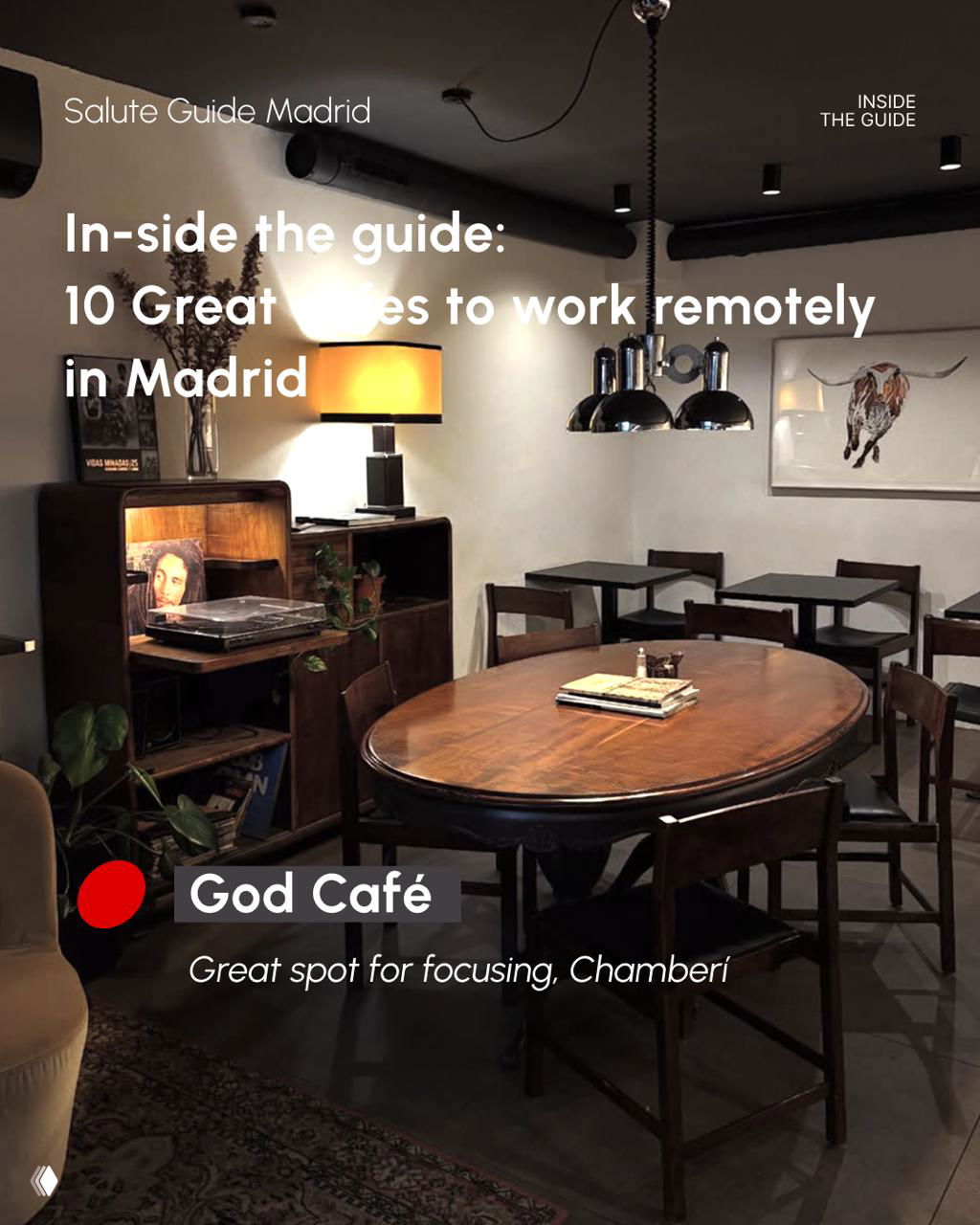 Cozy dimly lit café interior with round wooden table and vintage decor; God Café shown as a focused work spot in Chamberí.