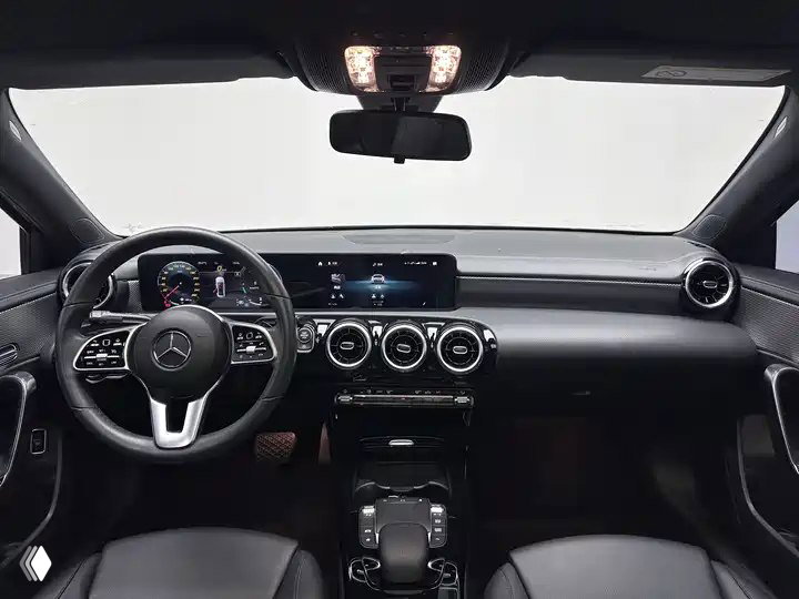 Салон Mercedes‑Benz A‑Class A 180 L Sport Sedan 2022: руль, приборная панель и мультимедиа-панель; тёмная отделка и современная цифровая панель.