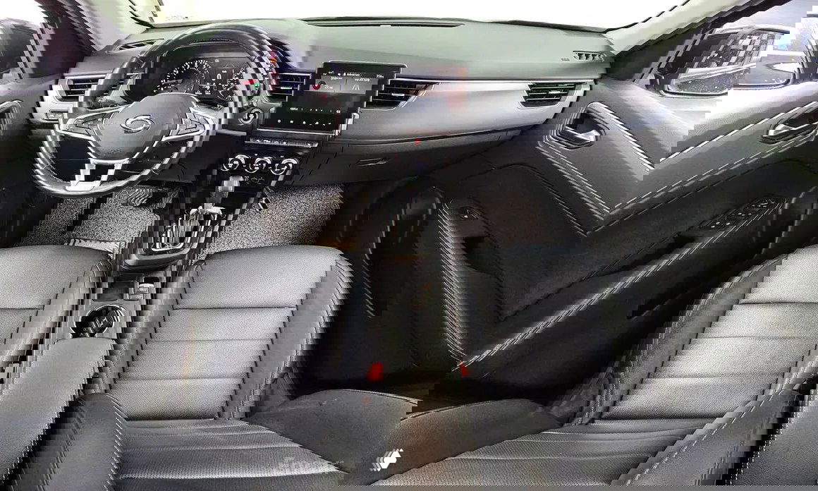 Интерьер Renault Samsung XM3: панель приборов, руль и центральная консоль с мультимедиа‑экраном, чёрная отделка сидений и общий вид салона.