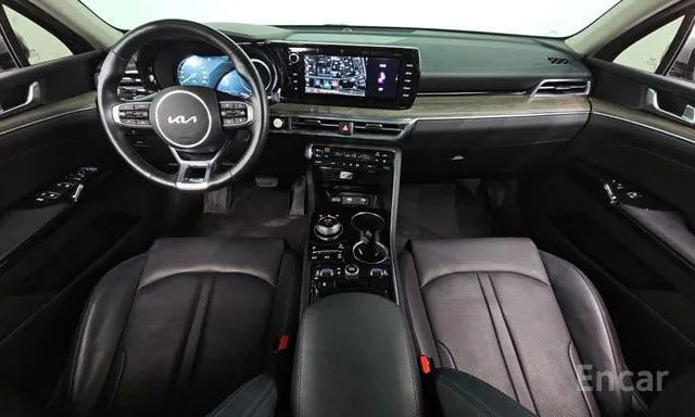 Салон Kia K5: панель приборов, большой экран мультимедиа и кожаные кресла в интерьере автомобиля, вид центральной консоли.