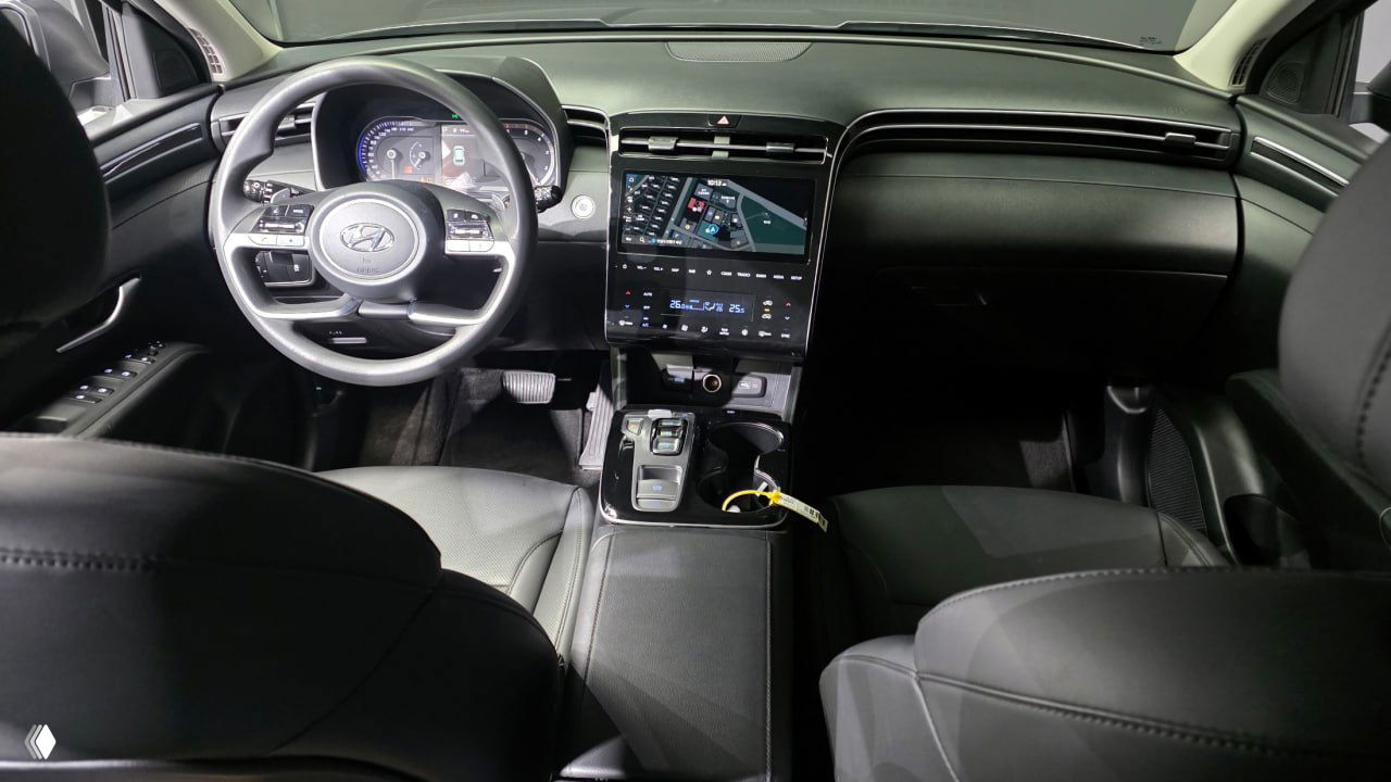 Интерьер Hyundai Tucson NX4: панель приборов и большой сенсорный дисплей, кожаные сиденья и центральный тоннель, вид со стороны задних кресел.