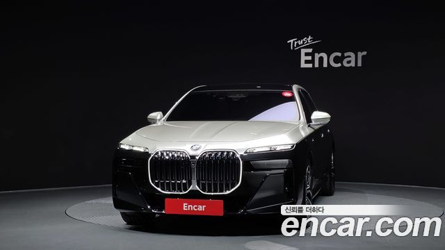 Строгий фронтальный ракурс BMW 7 Series 740d xDrive M Sport 2025 на тёмном фоне с акцентом на крупную решётку радиатора и эмблему BMW.