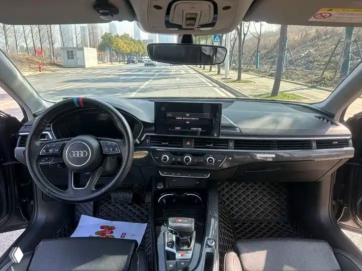 Интерьер Audi A4L: передняя панель, руль и мультимедийный экран; снимок салона показывает оборудование и состояние отделки автомобиля.