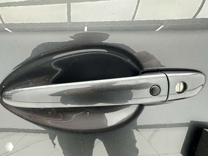 Крупный план дверной ручки Mazda CX-5 2026 и участка кузова: видны кнопка открытия и состояние лакокрасочного покрытия на чёрном элементе.