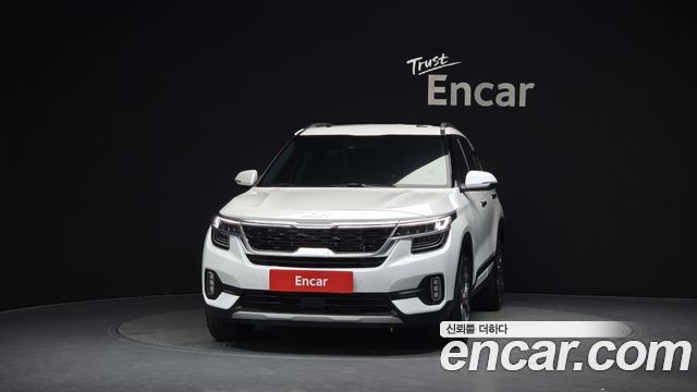 Фронтальный вид белого Kia Seltos 1.6 2WD 2021 в студии, крупный план передней части и фирменной решётки, фото для объявления из Кореи