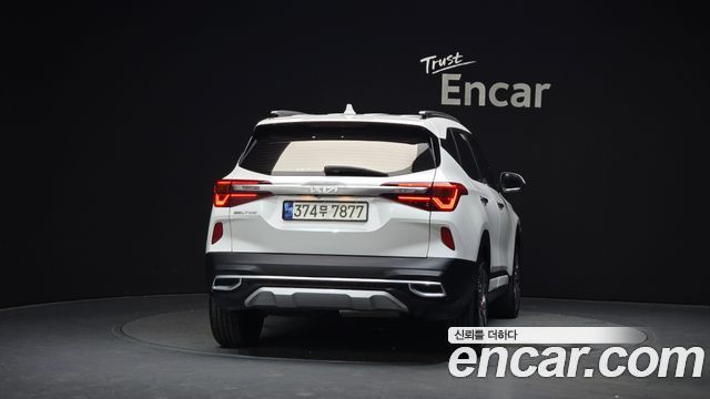 Задняя часть белого Kia Seltos 2021 с корейскими номерными знаками в студийной съёмке, акцент на форме багажника и оптике для продажи в РФ