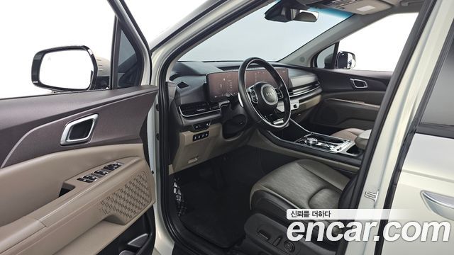 Салон Kia Carnival HEV 2024: панель приборов, мультимедиа-дисплей, мультифункциональный руль и передние кожаные кресла в хорошем состоянии.