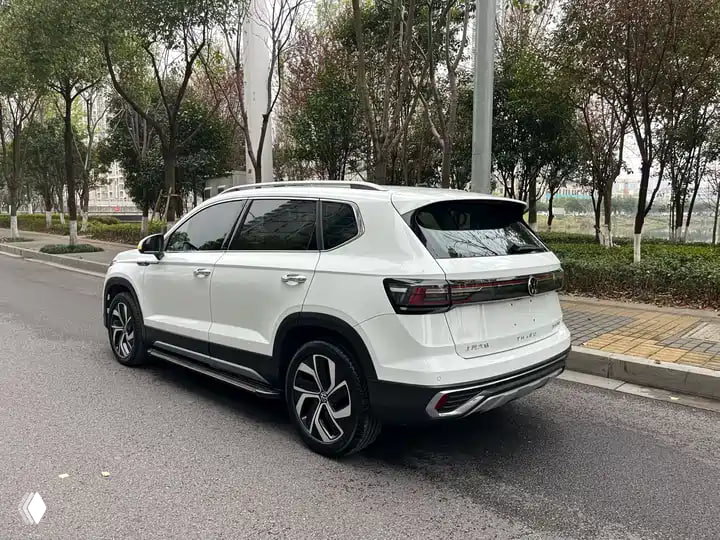 Белый Volkswagen Tharu 2023 — задний трёхчетвертной вид на фоне тротуара и деревьев в Китае, заметны задние фонари, линии крыши и задний бампер.