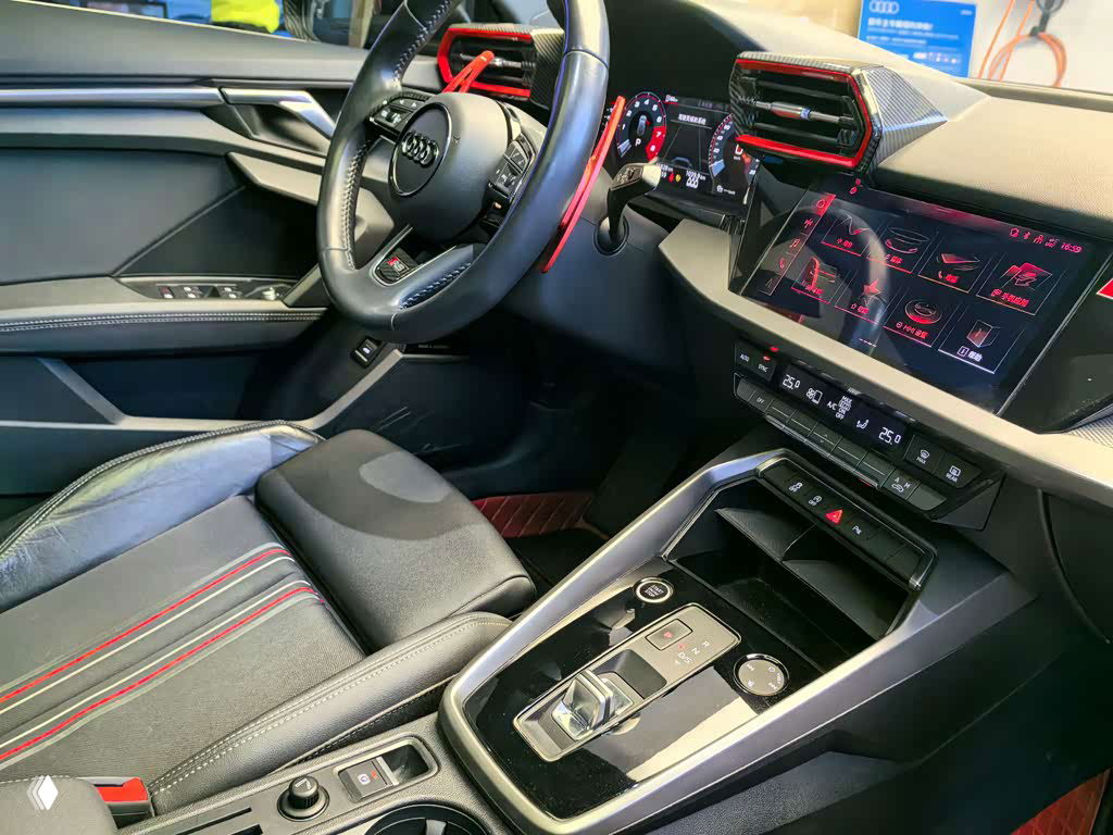 Крупный план центральной консоли и переднего пассажирского сиденья Audi A3 2022 с декоративными вставками и элементами управления.