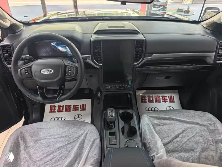 Панель приборов и центральная консоль Ford Ranger: вертикальный тачскрин, рулевое колесо с логотипом Ford, вид с водительского места.