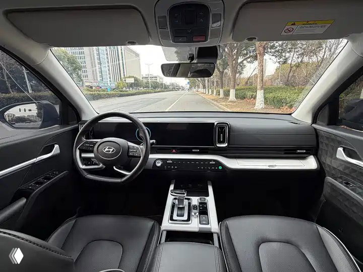 Салон Hyundai ix35 2023: передняя панель, руль, центральная консоль с мультимедиа и селектором автомата, чёрная отделка сидений