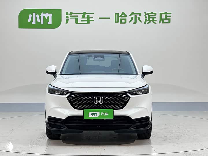 Белый Honda XR‑V 2023 в шоуруме, фронтальный ракурс; заметны фары, фирменная решётка и зелёная дилерская табличка на номере.