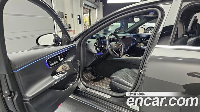 Снимок салона Mercedes‑Benz E450 4MATIC 2024: передняя консоль, мультимедиа, подсветка дверных панелей и часть кожаных сидений