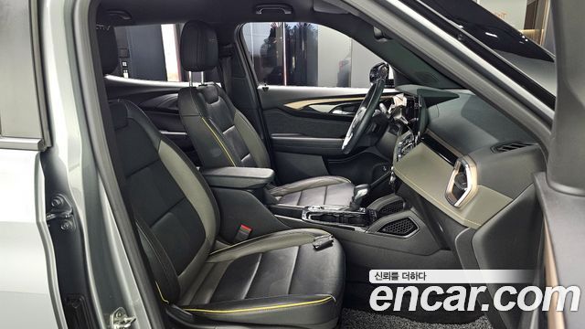 Фотография салона Chevrolet Trailblazer 2024: передние сиденья, центральная консоль и элементы отделки, интерьер серо-чёрного тона.