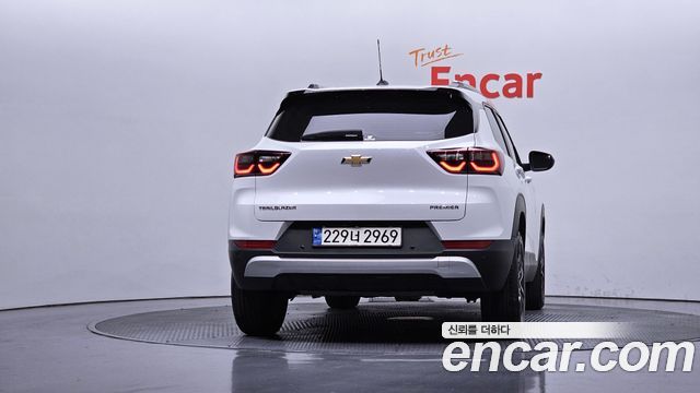 Белый Chevrolet Trailblazer 2023 в студии Encar — вид сзади на поворотной платформе, читается корейский номерной знак и общий профиль автомобиля.