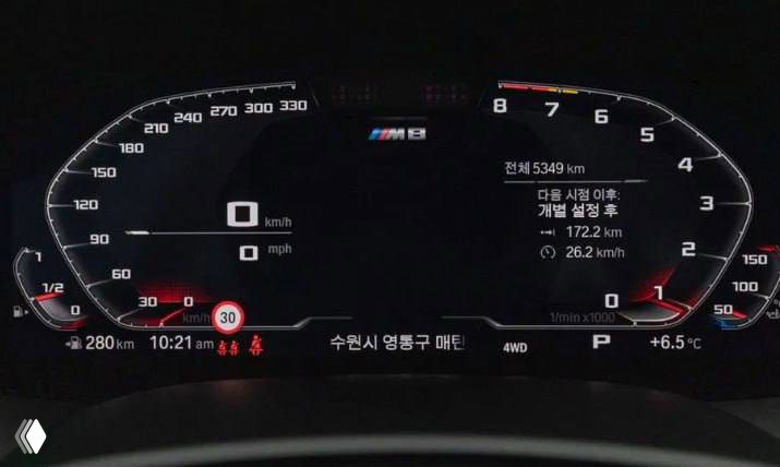 Цифровая приборная панель BMW M8 с индикатором скорости, логотипом M8 и корейскими надписями на дисплее — подтверждение пробега и комплектации.
