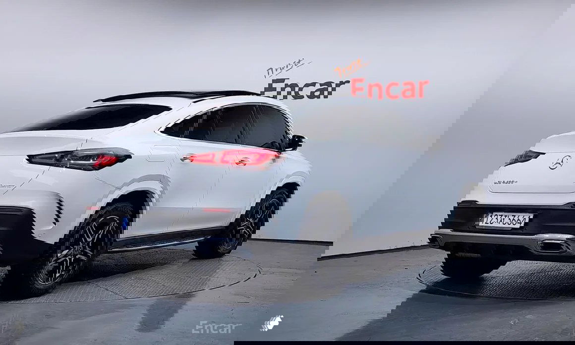 Задний ракурс белого Mercedes‑Benz GLE‑Class Coupe (C167) на студийной площадке Encar, видно кормовую часть, фары и номерную табличку.