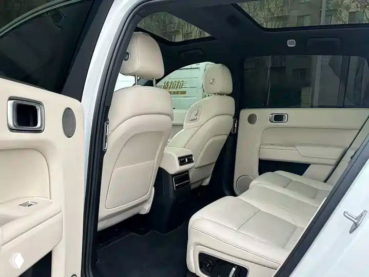 Задние сиденья Li Auto L7 в светлой коже: просторный второй ряд, подлокотник и отделка, фото показывает место для пассажиров и состояние обивки.
