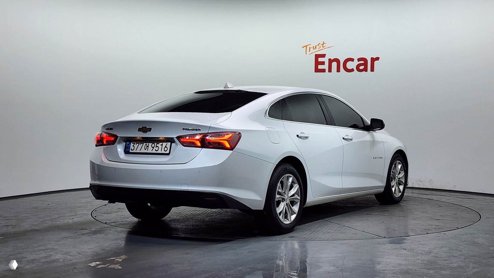 Белый Chevrolet Malibu 2021 Premier, задний ракурс в студии Encar: видна корейская регистрация и шильдик Premier, кузов без явных дефектов.