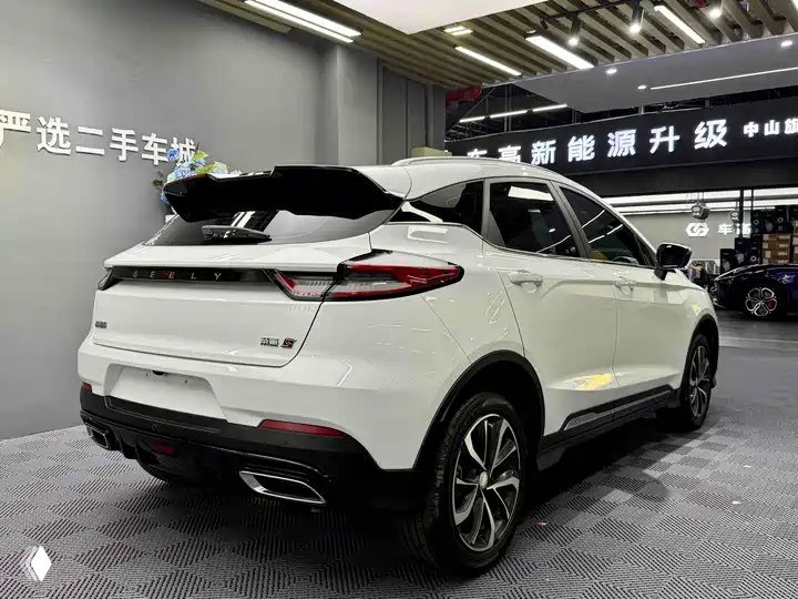 Задний ракурс Geely Emgrand S 2022 в салоне: открытый багажник, спойлер, LED‑фонари, рельефный бампер и стильные хромированные патрубки
