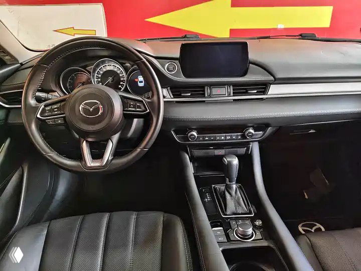 Салон Mazda Atenza 2021: чёрные сиденья, руль, приборная панель и центральная консоль с мультимедиа-экраном.