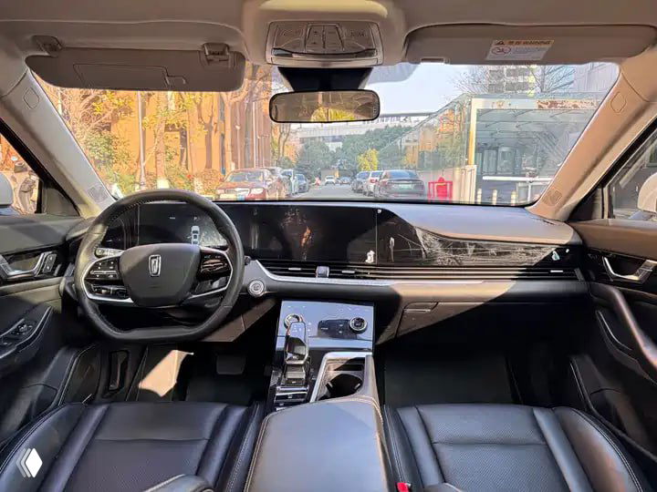 Салон и панель приборов Bestune B70: рулевое колесо, большой экран мультимедиа, центральная консоль и передние кожаные кресла.