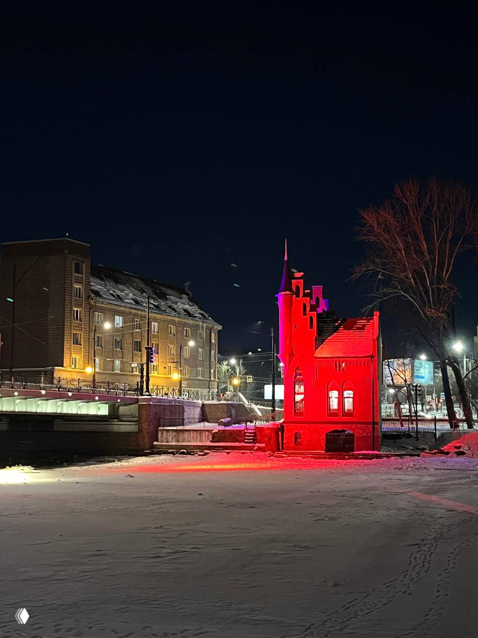Широкий план Домика смотрителя и набережной у Высокого моста ночью: яркая красная подсветка, заснеженные берега и лёд на Преголе.