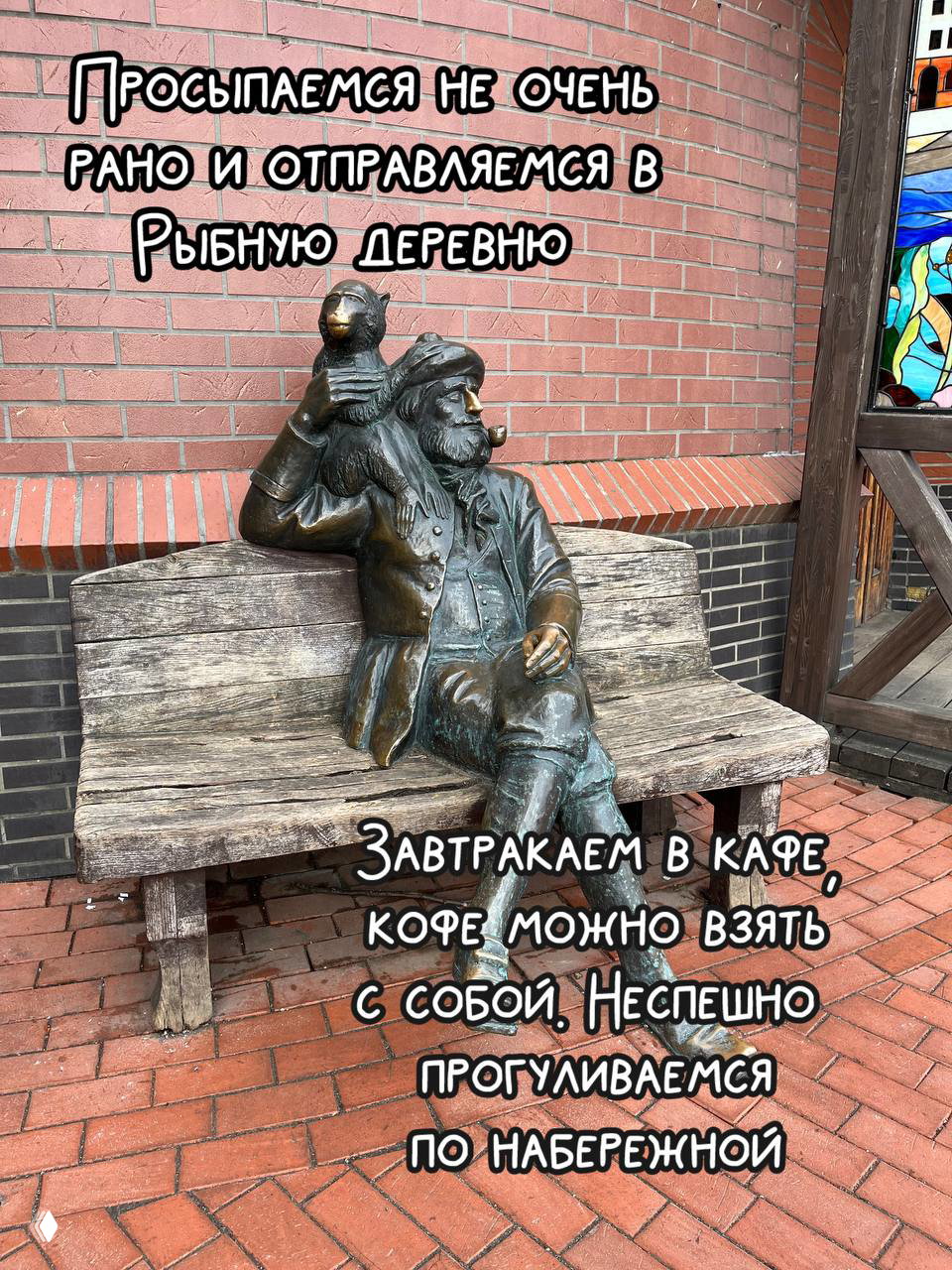 Бронзовая скульптура мужчины с птицей на скамье у кирпичной стены в Рыбной деревне — атмосферный городской арт‑объект для фотографий.