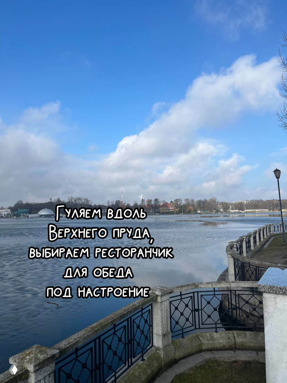 Набережная Верхнего пруда с ограждением и спокойной водой, отражающей небо — приятная прогулочная зона для обеда и отдыха.