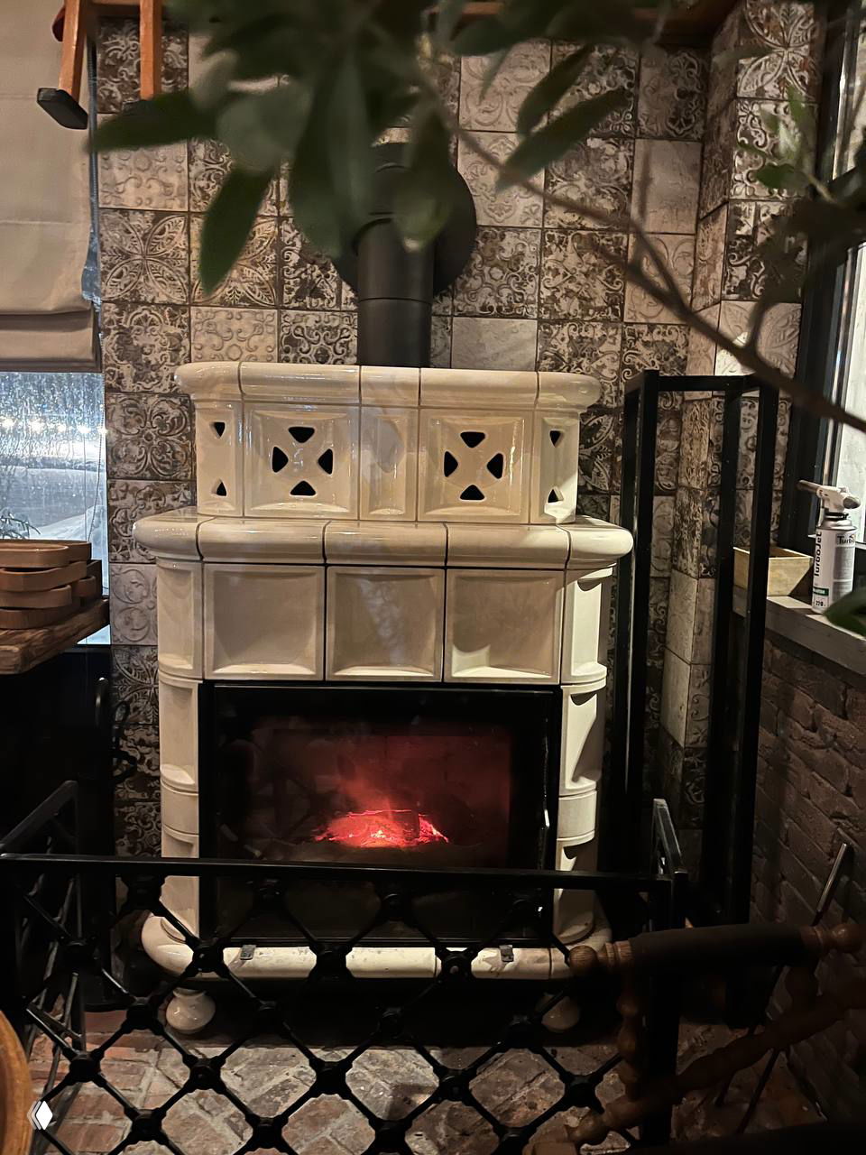 Камин в керамической печи с горящими углями: тёплый акцент интерьера ресторана, создающий домашнюю атмосферу в холодный вечер.