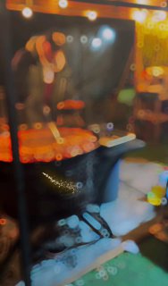 Размытое ночное фото фудкорта и сценического освещения на ярмарке: огни, тёплая атмосфера и признаки уличной еды в кадре.