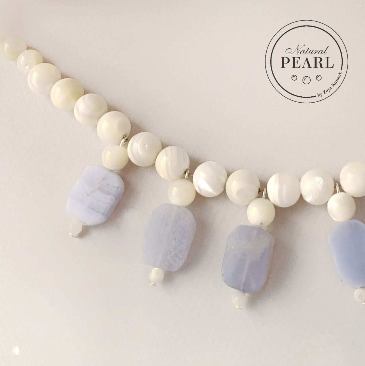 Крупный план подвесок из светло-голубого сапфирина и округлых перламутровых бусин; видны фактура камня и серебристые разделители.