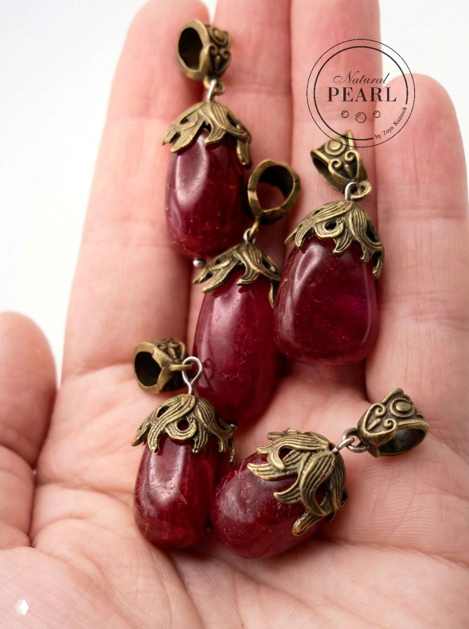 Крупный план тонированных кварцевых кулонов в ладони: видны бронзовые шапочки, фактура камня и фирменный штамп Natural PEARL.