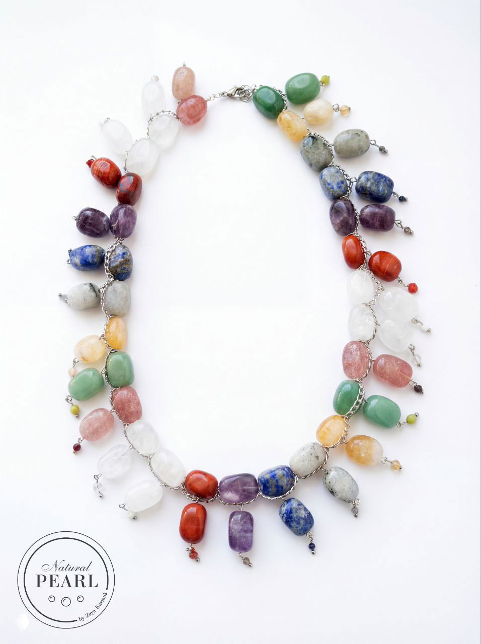 Колье «Наваратна» аккуратно разложено на белом фоне: видно расположение камней в три ряда и отдельные подвески с мелкими бусинами.