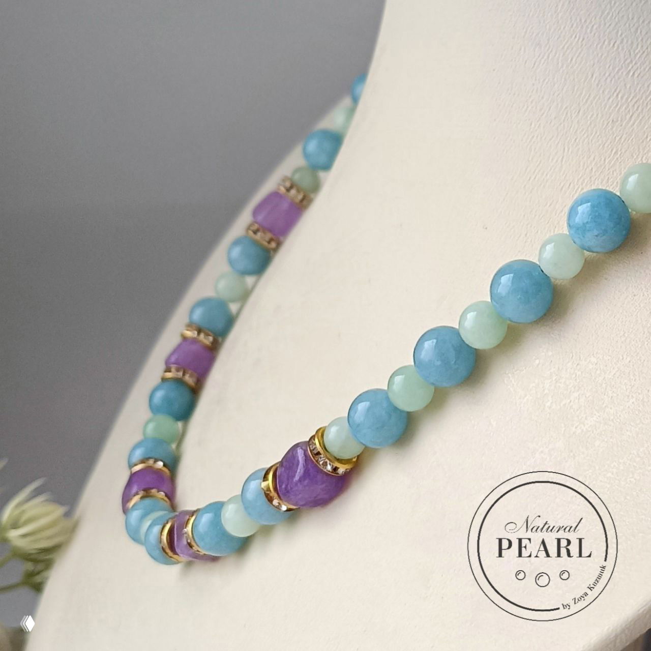 Крупный план колье «Морской бриз»: голубые и светло‑зеленые круглые бусины с фиолетовыми вставками, вид фактуры и огранки