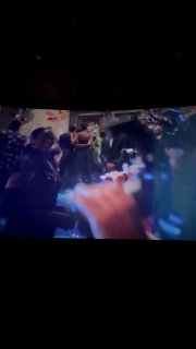 Размытый кадр с экрана: светская сцена в фильме с гостями и фотографами, заметны вечерние платья и общая атмосферность события.