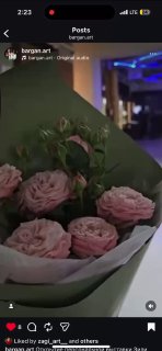 Превью видео: букет светло-розовых роз в выставочном зале, на заднем плане мягкое фиолетовое освещение и размытый интерьер.